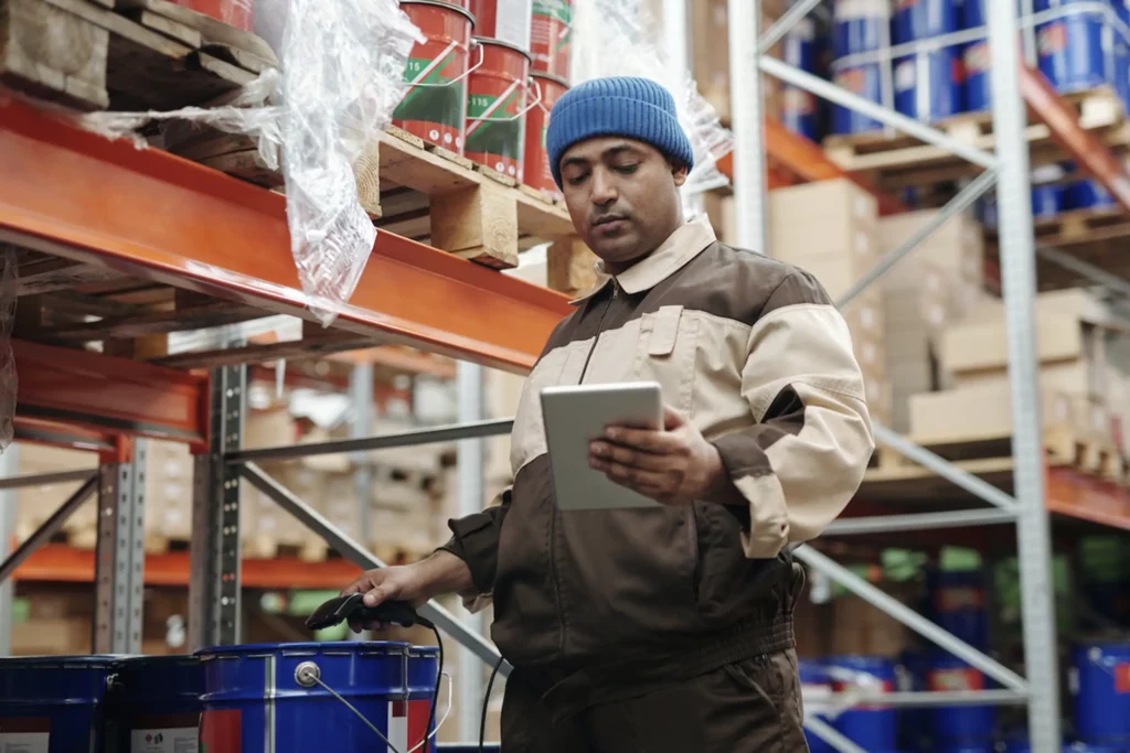 man standing in warehouse with tablet