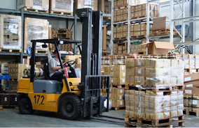 a man driving a forklift in a warehouse