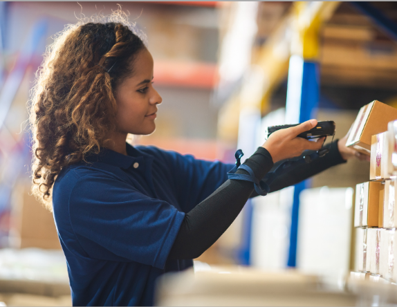 female warehouse worker scanning a box with a handheld device
