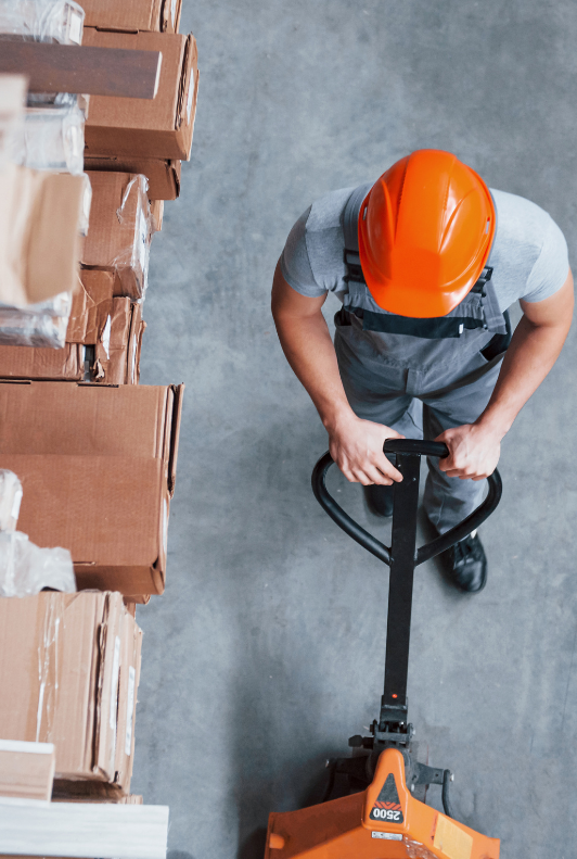 warehouse working pushing a hand pallet truck
